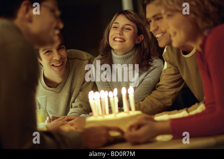 Les amis réunis présentant le gâteau d'anniversaire à un ami Banque D'Images