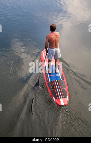 Aman sur un paddleboard standup, flotteurs les eaux fraîches de la rivière Deschutes dans le Old Mill District dans la région de Bend Oregon Banque D'Images