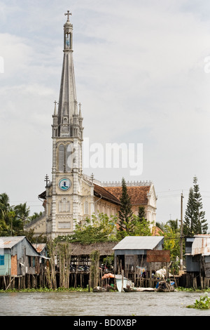 Une église derrière un village flottant dans le Delta du Mekong, Vietnam Banque D'Images