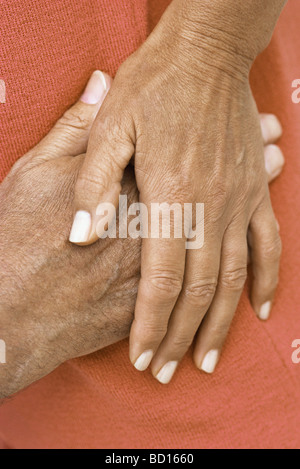 Woman's main reposant sur le dessus de la main de l'homme, close-up Banque D'Images