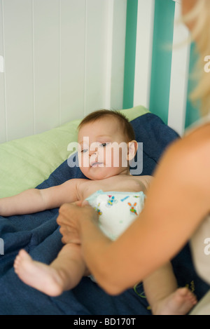 Femme de changer la couche de bébé Banque D'Images
