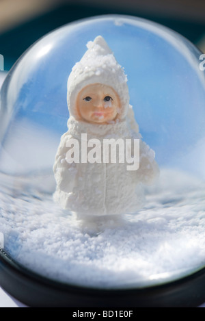 Snow globe, figurine de little girl wearing hat manteau d'hiver et à out Banque D'Images