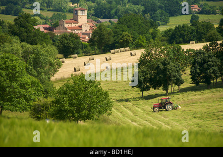 Agriculteur de son tracteur faire hays en Auvergne. La France. Banque D'Images