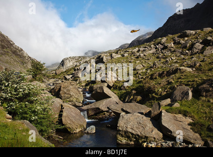 Hélicoptère de sauvetage de la RAF survolant le col de Llanberis, parc national de Snowdonia (Eryri), pays de Galles du Nord Banque D'Images