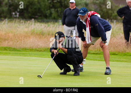 Marcus Brier golfeuse professionnelle et son caddy alignement d'un putt sur le green de Kilmarnock Barassie Golf Club, Troon, Ecosse, Banque D'Images