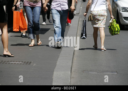 Young couple holding hands walking in town Banque D'Images