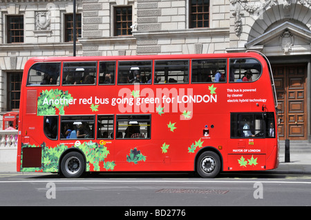 Vue latérale du bus à impériale rouge qui passe au vert Pour les transports en commun à Londres et équipés d'un aspirateur technologie hybride électrique Angleterre Royaume-Uni Banque D'Images