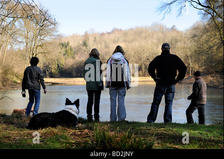 Un petit groupe de marcheurs occasionnels par un lac gelé dans le Gloucestershire UK FORESTIERS Banque D'Images