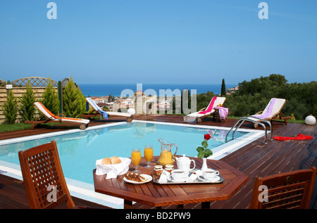 Petit déjeuner pris en plein air près de la piscine à une villa de vacances Banque D'Images