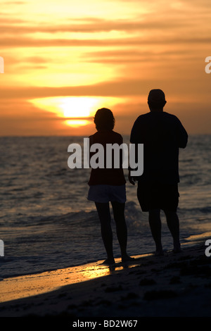 Couple regardant le coucher du soleil sur la plage de Bowman - Sanibel Island, Floride Banque D'Images