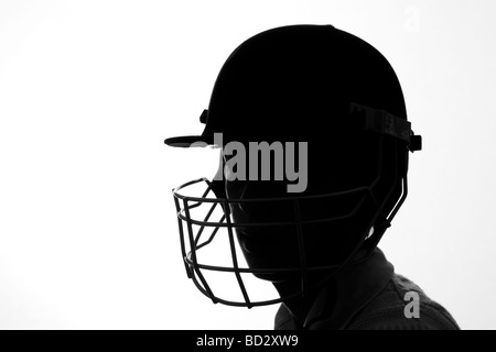 Silhouette de garçon dans le cricket casque avec grill face Banque D'Images