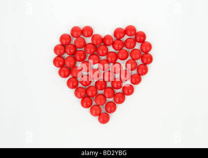 La vie toujours tourné artistique de l'ensemble des bonbons rouges en forme de coeur prises sur un fond blanc. Banque D'Images