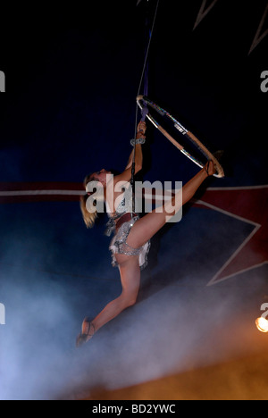 Artiste de cirque à l'aide de acrobat cerceau aérien aussi connu sous le nom de "Cerceau" ou "Lyra" un appareil d'acier circulaire Banque D'Images