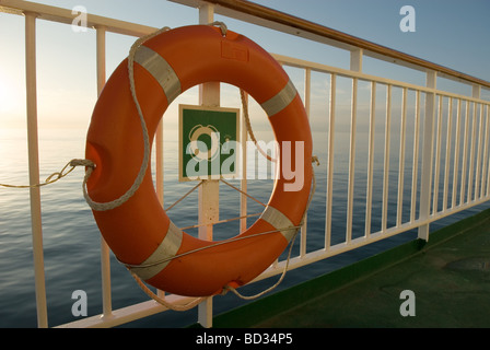 Anneau attaché à la vie sur les garde-corps passerelle ferry canal au coucher du soleil Banque D'Images