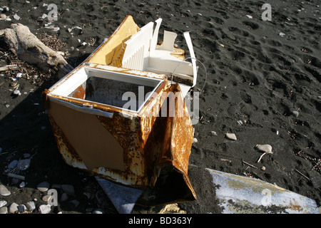 Vieux frigo congélateur abandonné sur la côte de sable de plage Banque D'Images