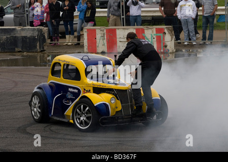 Terry Grant cascadeur sort de sa voiture tout en effectuant une cascade dans le cadre de son spectacle à Santa Pod Banque D'Images