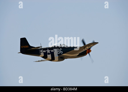 Un P-51 Mustang vole à un meeting aérien, cette Mustang a peint des bandes d'invasion sur elle. Banque D'Images