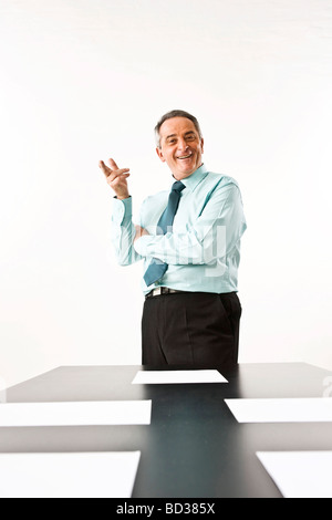 Gestionnaire de rire devant son bureau Banque D'Images