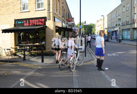 2 vélos femme marche sur Broadway Market Londres Hackney Banque D'Images