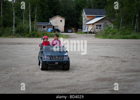 Deux jeunes autochtones rouler une petite voiture dans la communauté algonquine Anicinape de Kitcisakik au Québec Canada Banque D'Images