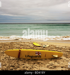 Un sauveteur RNLI surf rescue board sur la plage de Sennen à Cornwall. Banque D'Images