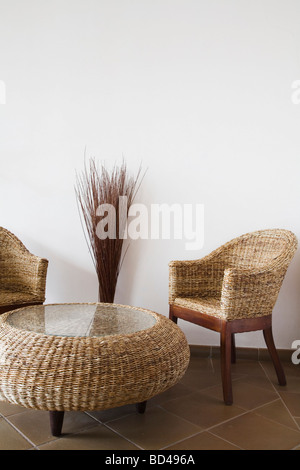 Table et chaises en osier contre un mur blanc with copy space Banque D'Images