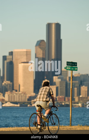 Un homme chevauche son vélo le long Alki Beach à Seattle, WA. Banque D'Images