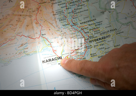 Indiquez avec un doigt la ville de Karachi sur une carte Banque D'Images
