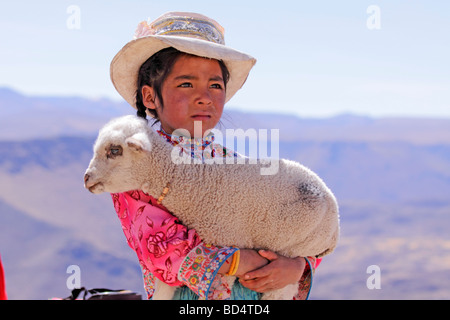 Portrait d'une jeune fille habillée traditionnellement tenant un agneau, près de Arequipa Banque D'Images