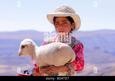 Portrait d'une jeune fille habillée traditionnellement tenant un agneau, près de Arequipa Banque D'Images