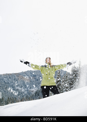 A woman throwing snow jusqu'à l'air Banque D'Images