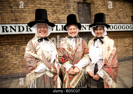Trois femmes habillées en costume traditionnel gallois de porter Paisley châles et de grands chapeaux stovepipe Llanfair PG anglesey au nord du Pays de Galles Banque D'Images
