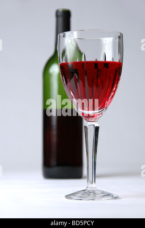 Verre de vin rouge avec une bouteille dans l'arrière-plan Banque D'Images