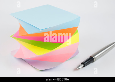 Postit notes autocollantes colorées avec stylo plume studio isolé sur fond blanc Banque D'Images