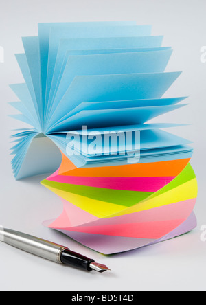 Postit notes autocollantes colorées avec stylo plume studio isolé sur fond blanc Banque D'Images