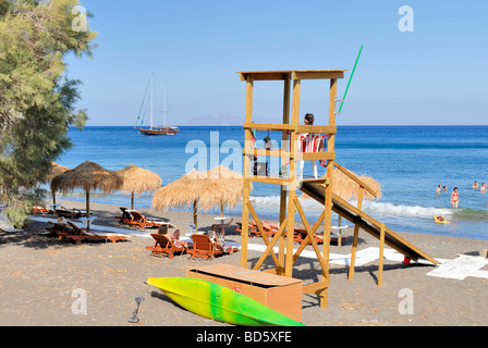 La plage de Perissa et lifeguard post. Plage de Perissa se composent de sable noir, qui devient très chaud pendant la journée ensoleillée. Perissa, Théra. Banque D'Images