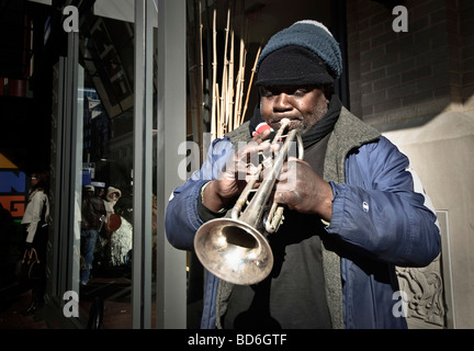 WASHINGTON DC, États-Unis — Un trompettiste de jazz se produit dans une rue du centre-ville de Washington DC. Le busker divertit les passants avec de la musique live, contribuant à la culture de rue dynamique de la capitale américaine. Banque D'Images