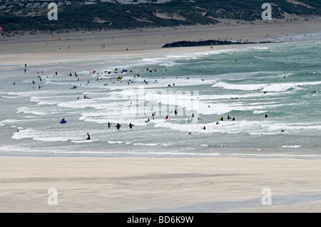 Vue de la plage de gwithian à Cornwall avec beaucoup de gens dans l'eau le surf et bodyboard Banque D'Images