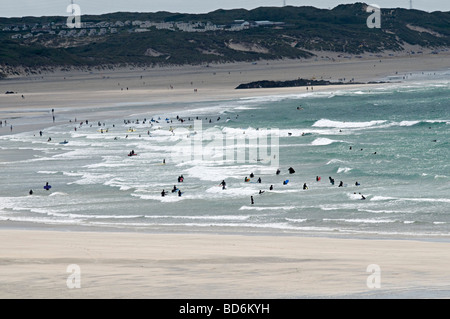 Vue de la plage de gwithian à Cornwall avec beaucoup de gens dans l'eau le surf et bodyboard Banque D'Images
