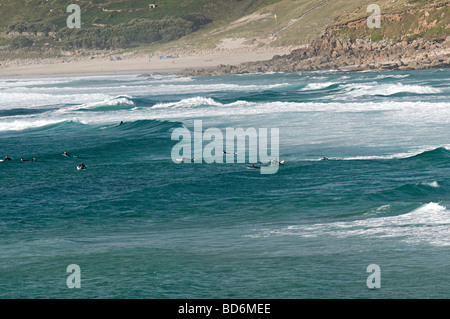 Surfeurs de sennen cove cornwall assis dans l'eau en attente d'une bonne vague Banque D'Images