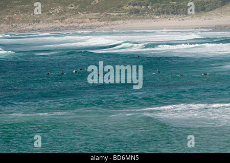 Surfeurs de sennen cove cornwall assis dans l'eau en attente d'une bonne vague Banque D'Images