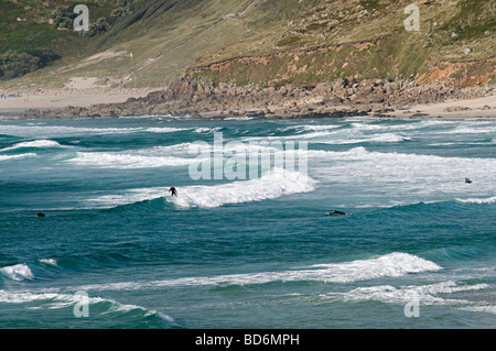 Surfeurs de sennen cove cornwall assis dans l'eau en attente d'une bonne vague Banque D'Images