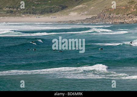 Surfeurs de sennen cove cornwall assis dans l'eau en attente d'une bonne vague Banque D'Images