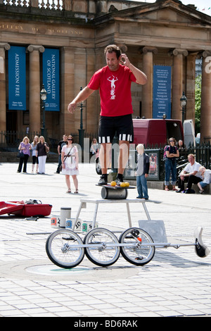 Un artiste de rue au cours de l'équilibrage d'une loi à l'extérieur de la galerie sur Edinburgh's mound pendant le Festival Fringe Banque D'Images