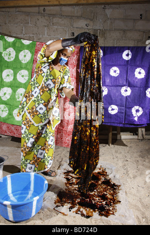 Femme portant un respirateur alors que la teinture batik tissu, travail à domicile, Maroua, Cameroun, Afrique Banque D'Images