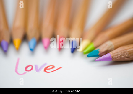 Mot d'amour de couleur sur papier et crayons de couleur Banque D'Images