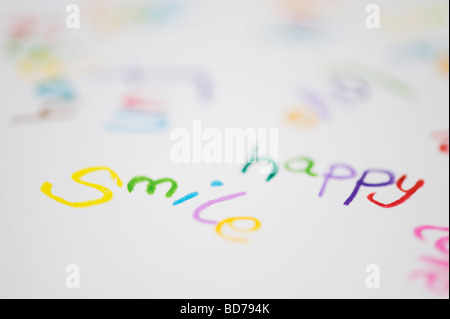Mot de couleur sourire, heureux et l'amour sur du papier écrit en crayons de couleur Banque D'Images