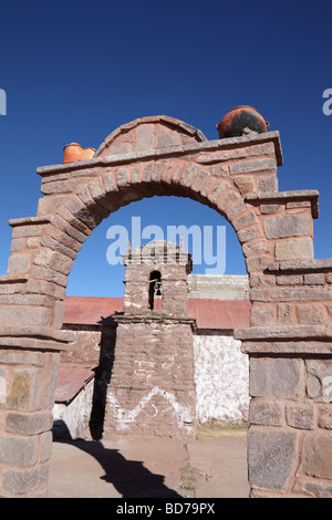 L'Adobe (brique de boue) tour de l'église encadrée dans une voûte en pierre , île de Taquile , le Lac Titicaca , Pérou Banque D'Images