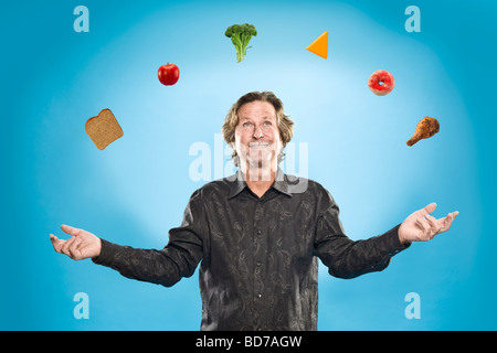 Man juggling différents aliments Banque D'Images