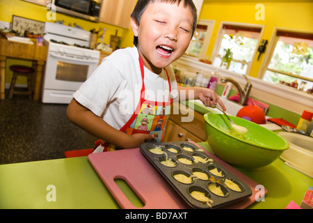 Jeune garçon faisant cupcakes Banque D'Images